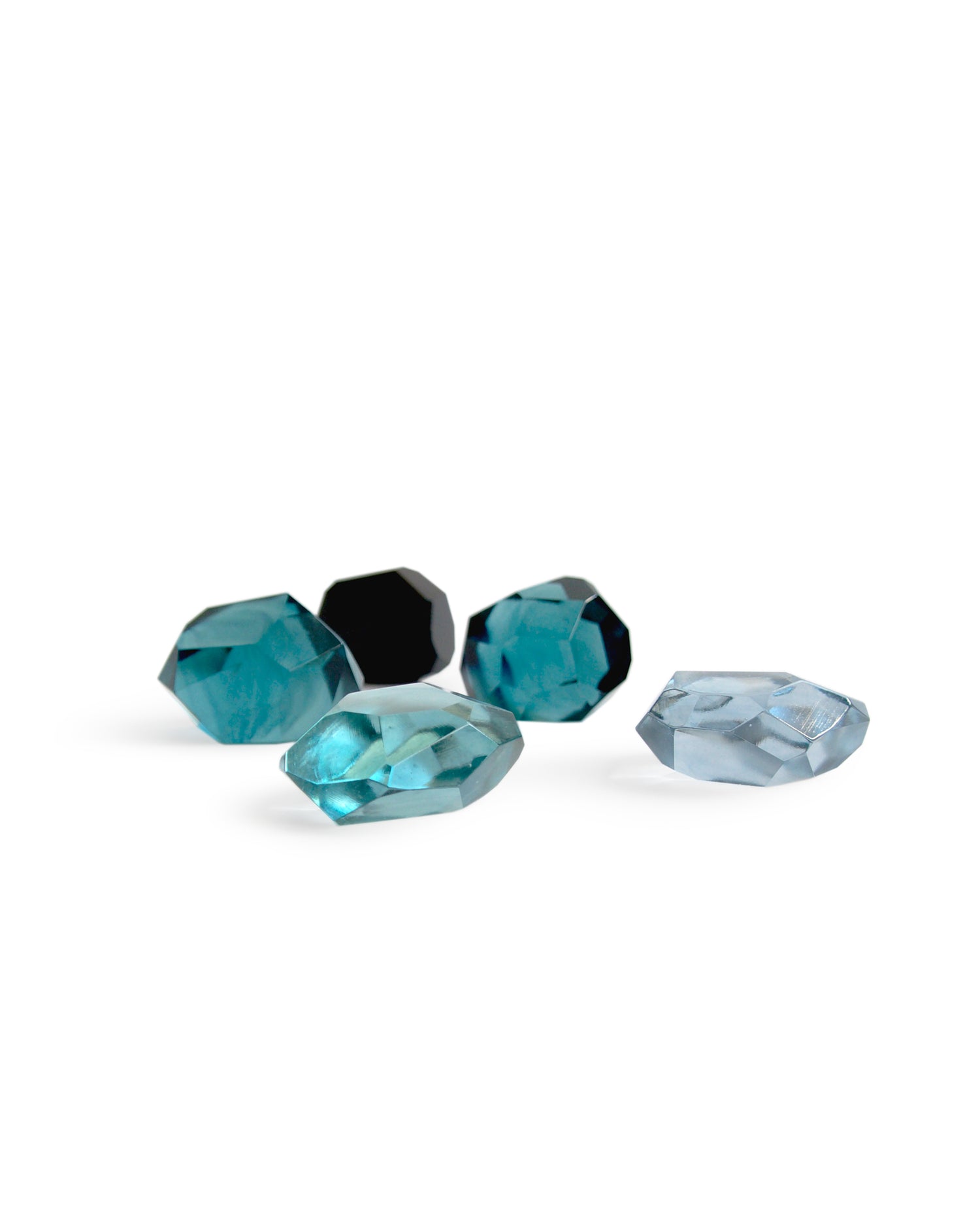 Silhouetted Reclaimed Blue Jewelry Cut Paperweights against white background. Features five paperweights in different shades of blue.