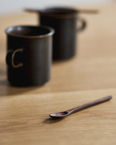 Walnut Coffee Spoon by Ryuji Mitani beside brown ceramic coffee cups