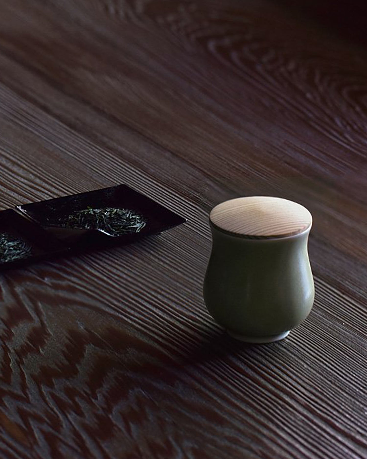 Cedar Lidded Green Gourd Teacup by Simplicity beside sencha tea leaves