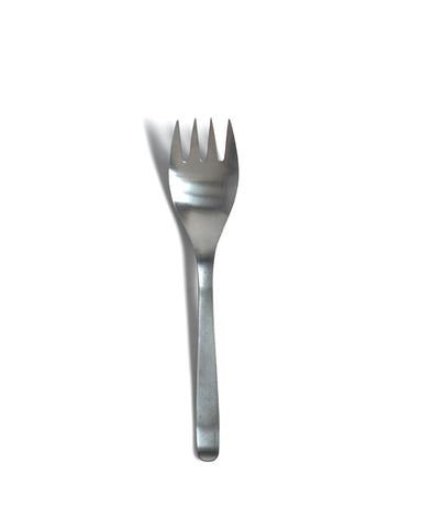 Silhouetted sori yanagi stainless steel serving fork against white background.